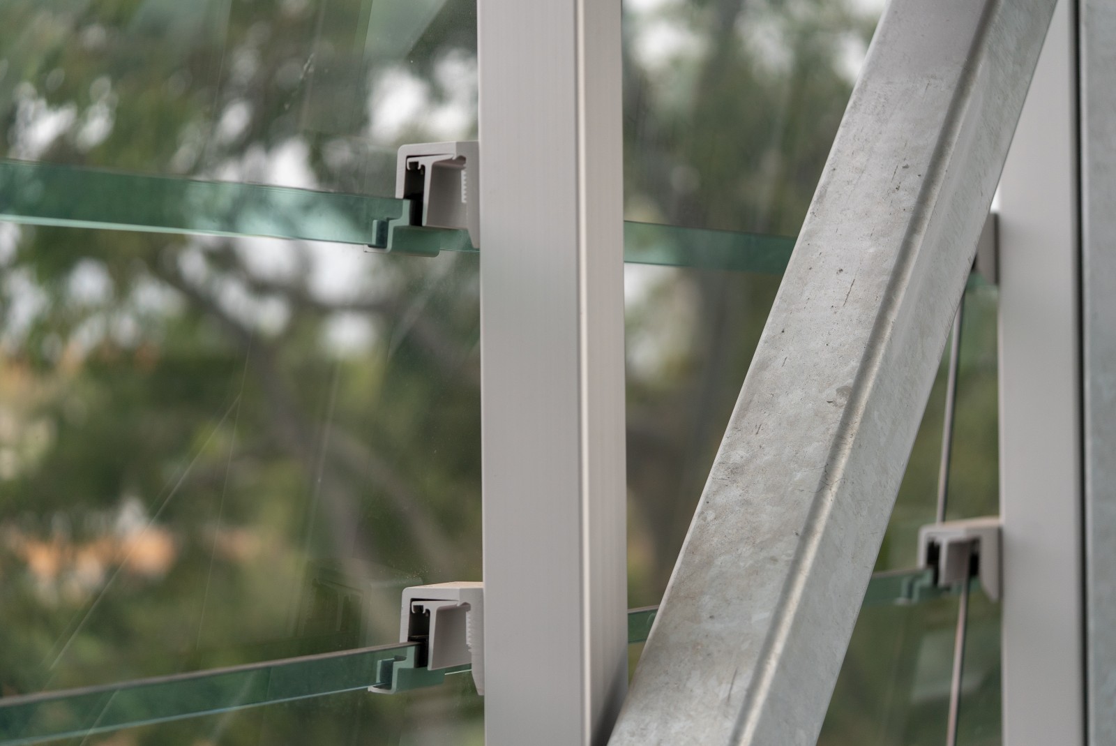 Fixed glass louvre brackets supporting overlapping glass blades on a steel frame